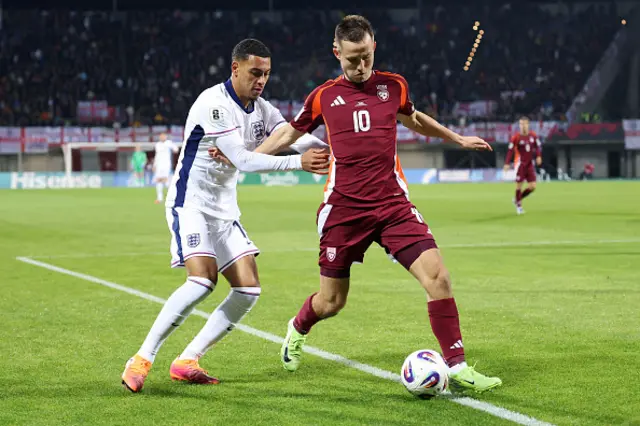 Morgan Rogers of England and Janis Ikaunieks of Latvia battle for possession