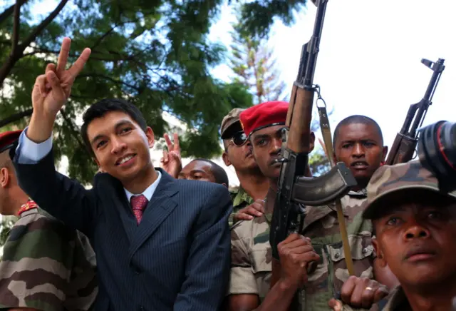 Madagascar opposition leader Andry Rajoelina (C) gives the V for victory sign as he parades through the streets of Antananarivo on March 17, 2009