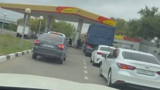 A queue of several cars and a lorry waiting outside a Rosneft garage