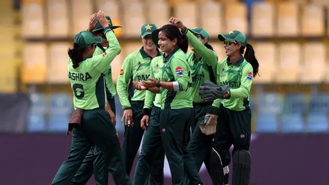 Fatima Sana of Pakistan celebrates with teammates after taking the wicket of Amy Jones