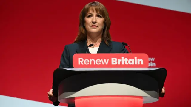 Rachel Reeves speaking on stage at the annual Labour party conference in front of a red background.