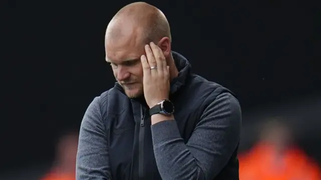 Norwich boss Liam Manning photographed looking deep in thought