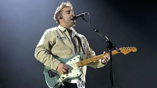 Sam Fender playing guitar and singing