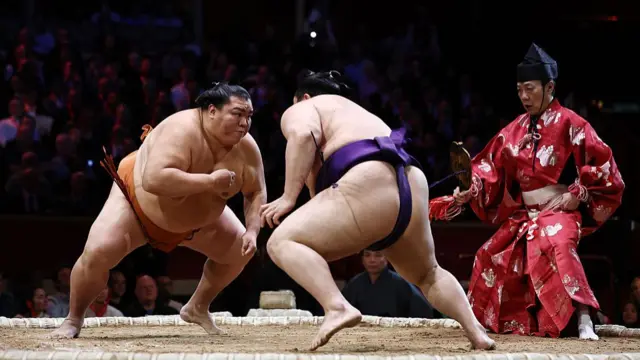 Mitakeumi (L) battles Churanoumi (R) during their bout on day 2 of the Grand Sumo Tournament at the Royal Albert Hall in central London