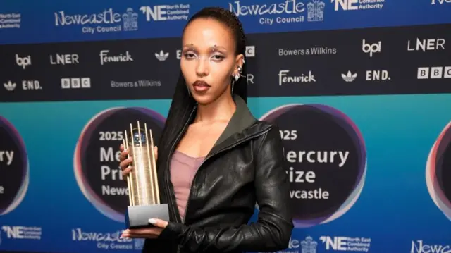 FKA Twigs poses on the red carpet with her nominee trophy