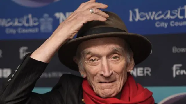 Folk singer Martin Carthy raises his hat while on the red carpet at the 2025 Mercury Prize awards