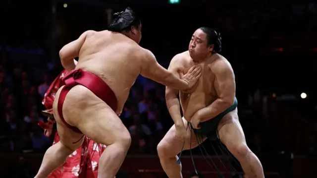 Daieisho (L) pushes Sadanoumi (R) during their bout on day 2 of the Grand Sumo Tournament at the Royal Albert Hall in central London