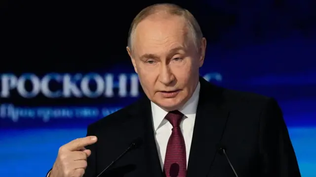 Vladimir Putin gestures to an audience