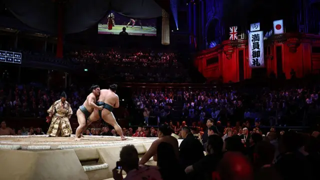 Nishikigi (L) battles with Asakoryu (R) in their bout on day 2 of the Grand Sumo Tournament at the Royal Albert Hall in central London on October 16, 2025.