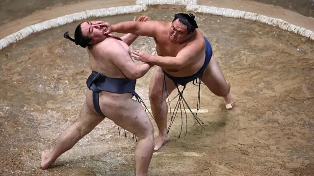 Tamawashi (R) battles with Kinbozan (L) during their bout on day 2 of the Grand Sumo Tournament at the Royal Albert Hall in central London