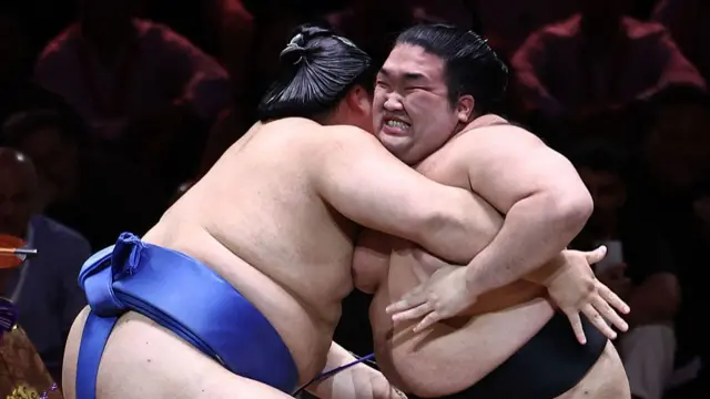 Gonoyama (R) battles with Yokozuna-ranked Onosato (L) during their bout on day 2 of the Grand Sumo Tournament at the Royal Albert Hall in central London