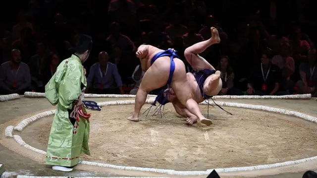 Kotoshoho (L) throws Ichiyamamoto (R) to win their bout on day 2 of the Grand Sumo Tournament at the Royal Albert Hall in central London on October 16, 2025.