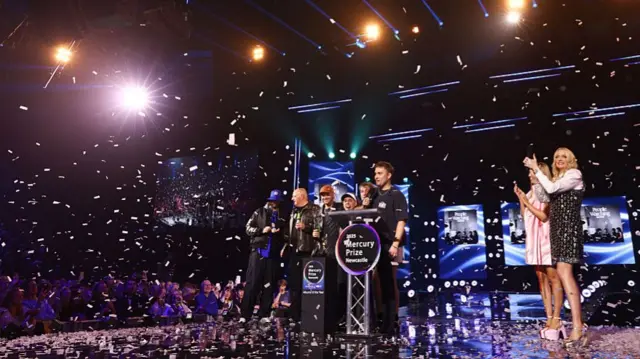 Fender stood on stage with his bandmates as confetti falls