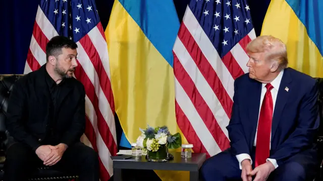 Trump and Zelensky sit opposite one another mid-speaking. Ukrainian and American flags are behind them