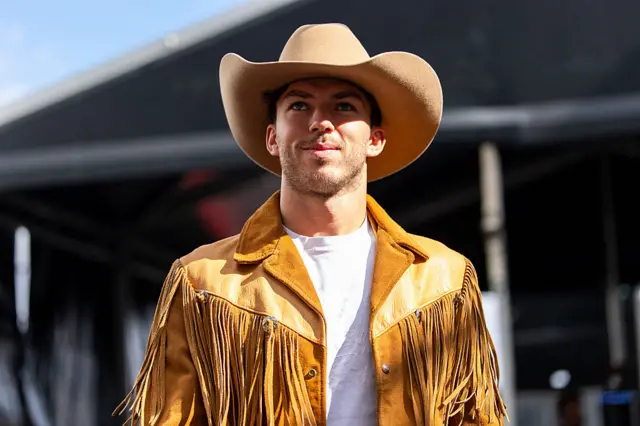 Pierre Gasly wearing a cowboy hat and fringe jacket in the Austin paddock