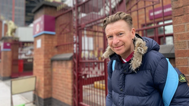 Lee Goodman stands in front of a gate