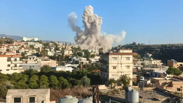 A photo shared by local media shows smoke rising south of the town of Bnaafoul between a municipal building on the crest of one hill and the trees and mast on the top of the hill opposite