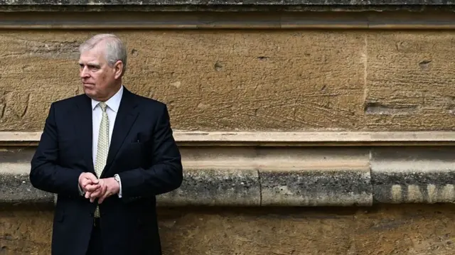 Duke of York stands next to a church wall