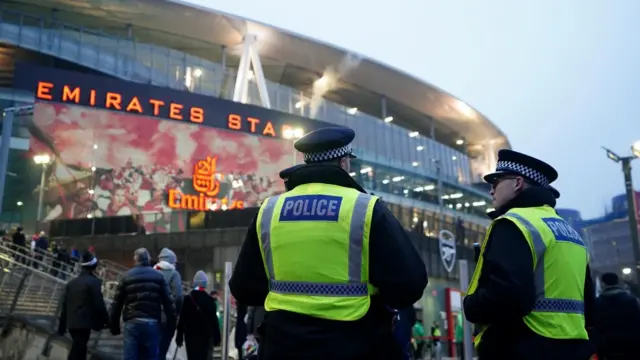 Two police officers stand outside Emirates Stadium in north London.