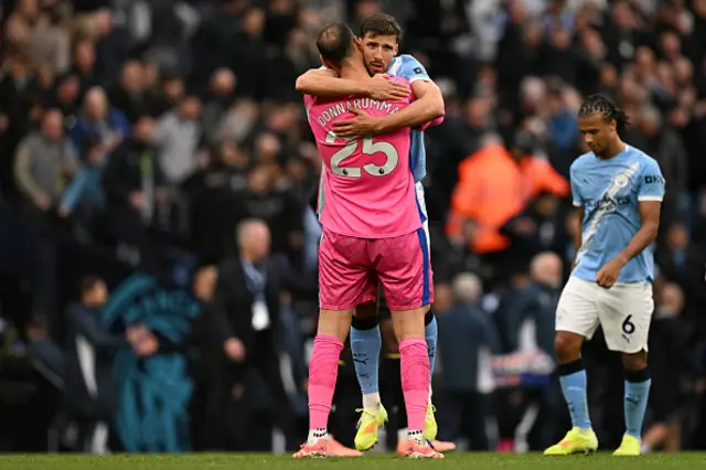 Gianluigi Donnarumma hugs Manchester City's Portuguese defender Ruben Dias