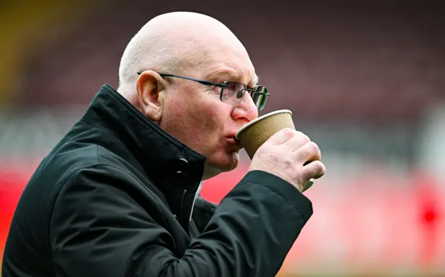 John McGlynn sips from a coffee cup
