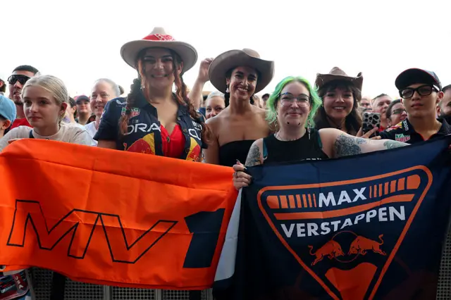 fans hold up signs for Max Verstappen in the fan zone in Austin