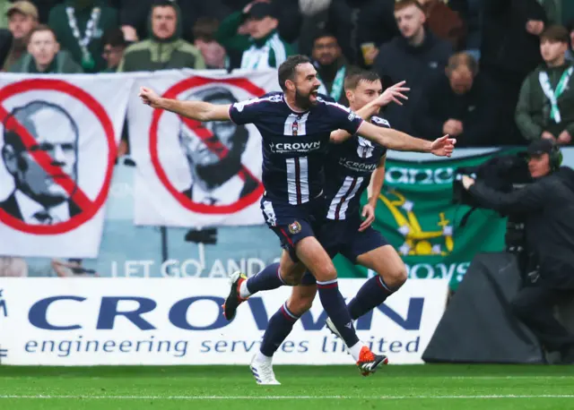 Clark Robertson celebrates in front of Celtic fan banners