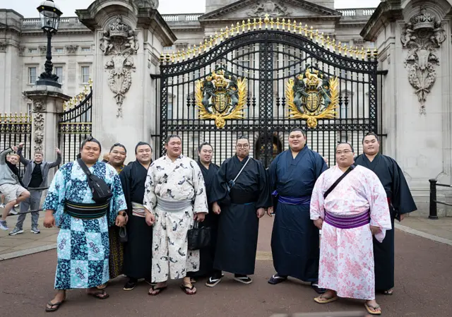 Sumo wrestlers stood in front of Buckingham Palace
