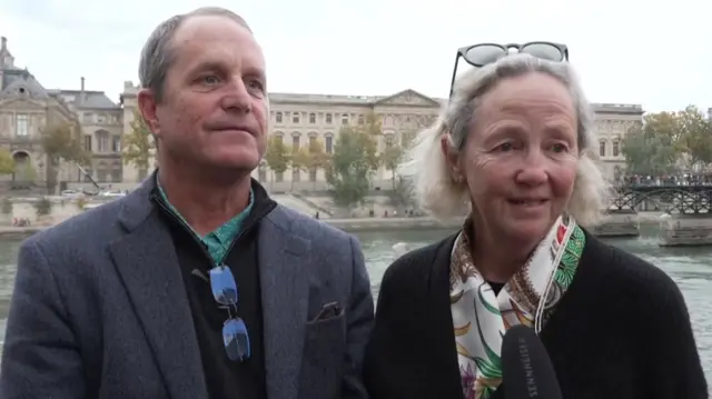 Jim and Joan Carpenter, American tourists, speaking to a reporter in the street beside the Seine.