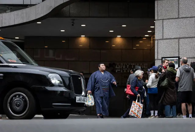 Atamifuji walks out of a Kensington hotel