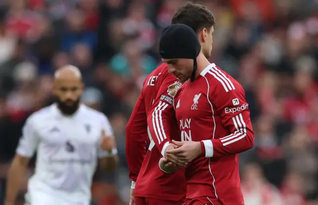 Mac Allister wears a head cap to protect his head injury