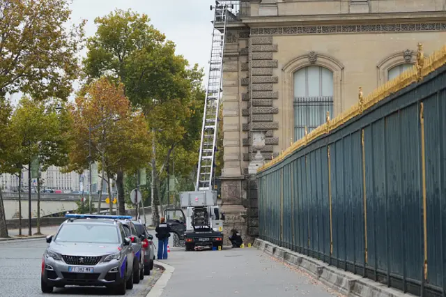 A ladder is seen with scientific police working beneath it at the Louvre museum