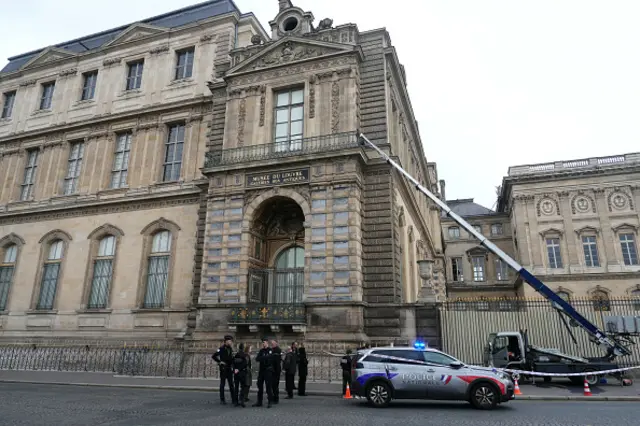 French police officers stand next to a furniture elevator outside the Louvre Museum