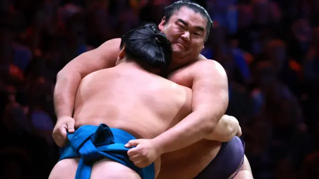 Two wrestlers push against each other