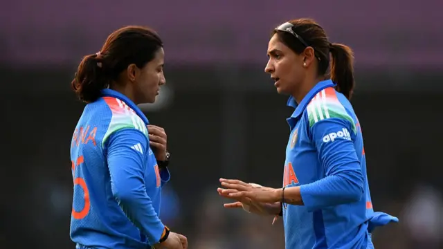 : Harmanpreet Kaur of India (R) speaks to team mate Sneh Rana