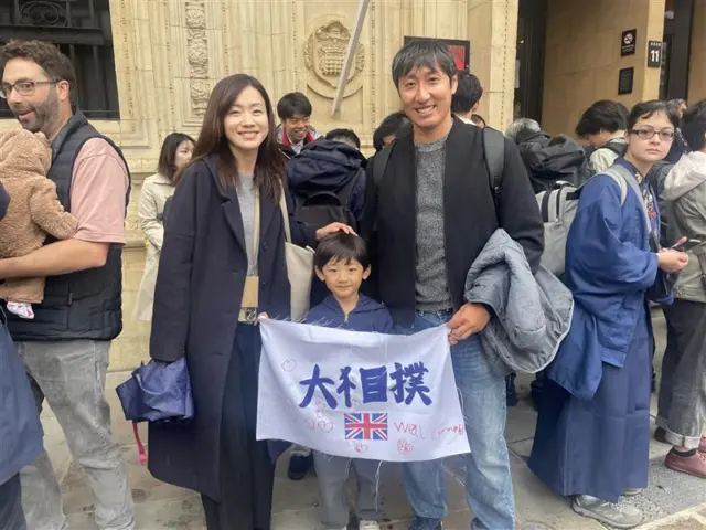 Yuma and his parents are currently wrestler spotting outside. Yuma’s banner says “grand sumo, well done!”