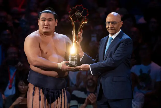 Hoshoryu holds aloft the Grand Champions Trophy