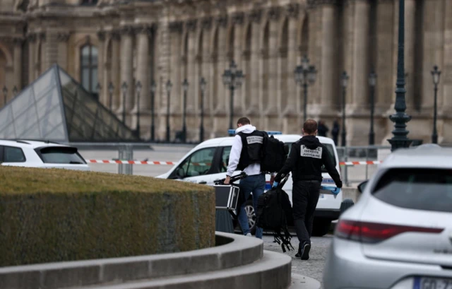 Forensic police officers arrive at the Louvre museum after reports of a robbery