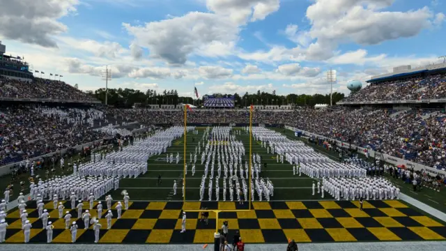 Sailors dressed in white on the football field ahead of a game