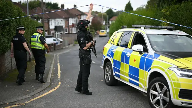 A police officer lifts a cordon near the synagogue