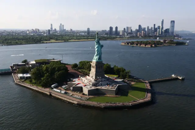 Aerial shot of the Statue of Liberty on Ellis Island with skyline in background
