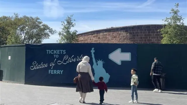 Tourists check out a ferry ride to the Statue of Liberty in New York City