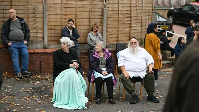 Members of Jewish community wait near cordon