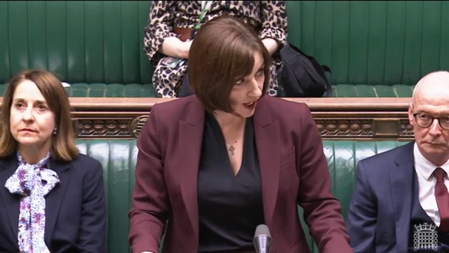 Phillipson in burgundy blazer addresses Commons