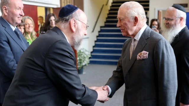 King shakes hands with a synagogue leader
