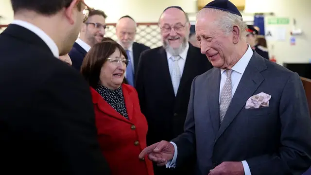 King Charles wearing a kippah having a laugh with members of the community