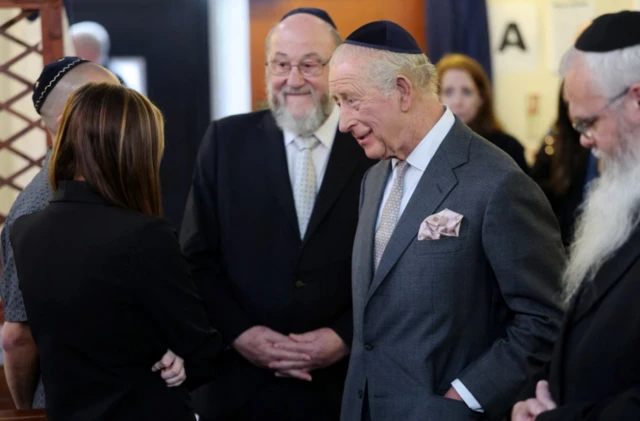 King inside the synagogue, wearing traditional head dress