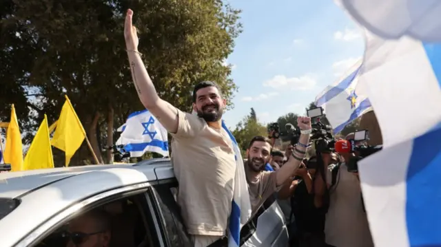 Released twin Israeli hostages Gali and Zivi Berman greet supporters as they return to their temporary home in Israel