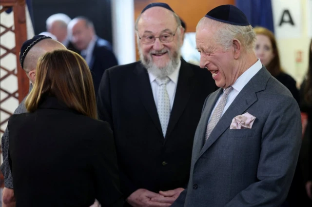 King Charles laughing as he speaks to the synagogue congregation