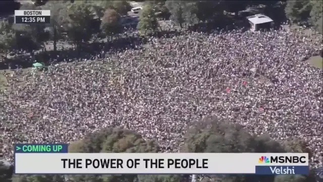 A screenshot from the MSNBC broadcast of the “No Kings” protest in Boston showing aerial footage of a large crowd in a park